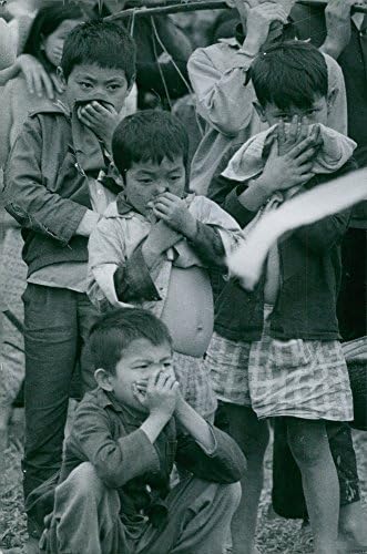 Реколта снимка на децата, закрывающих носа заради проблеми с дишането. Виетнам